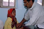Doctor examining patient in a village clinic by Reinhold Loeffler