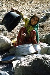 Girl washing pots in the river at a herding outpost in Boir Ahmad by Reinhold Loeffler