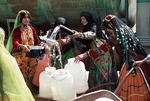 Women fetching water from a water truck en Boir Ahmad by Reinhold Loeffler