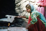 Daughter of fieldworker attempting to bake bread by Reinhold Loeffler