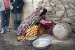 Woman Milling Grain with Stone by Reinhold Loeffler