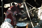 Woman churning yoghurt for butter in a goatskin bag in Boir Ahmad